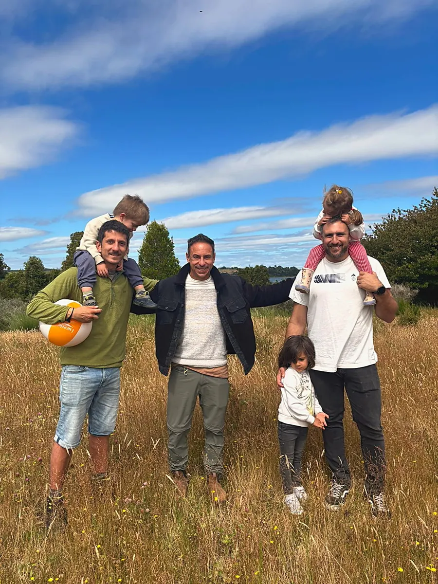 Tres padres con sus hijos en la pradera